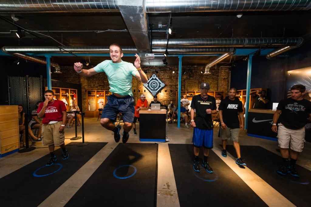 Teammates compete against each other in the standing high jump at the Nike Fieldhouse during an event held in conjunction with the 2012 Collegiate World Series in Omaha, Nebraska.