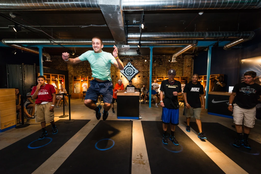 Teammates compete against each other in the standing high jump at the Nike Fieldhouse during an event held in conjunction with the 2012 Collegiate World Series in Omaha, Nebraska.